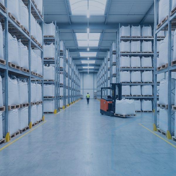 Các bao nguyên liệu dạng bột xếp trên pallet trong kho hàng, minh họa tồn kho nguyên liệu phosphate đóng bao