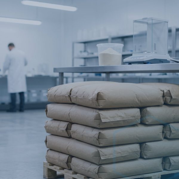White crystalline L-Lysine Monohydrochloride grades powder shown beside 25kg packaging bags
